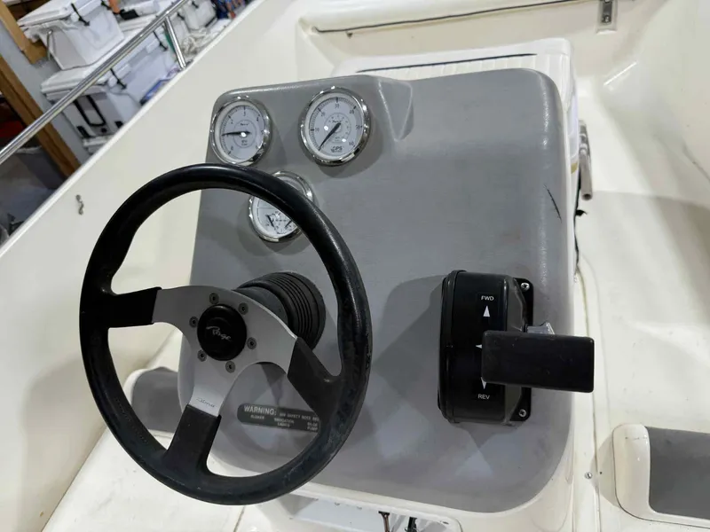 Slide: The Image of 1997 Boston Whaler Rage 15 dashboard with steering wheel and control panel. - 9