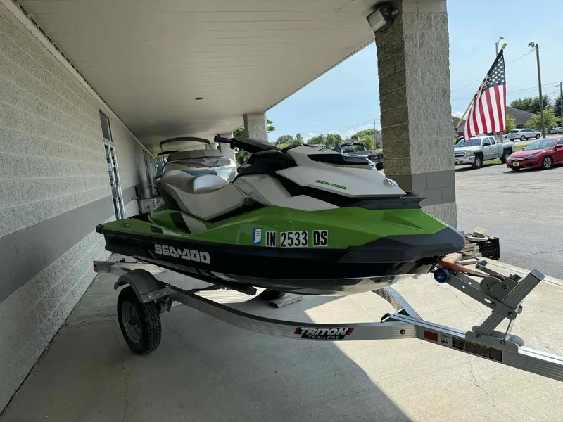 The Image of 2013 Sea-Doo GTI SE 130 jet ski on trailer, parked under a canopy. - 0