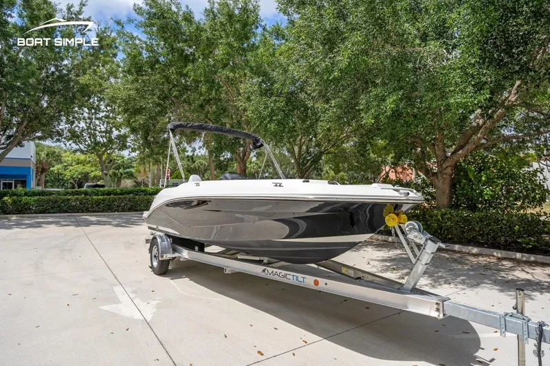 Slide: The Image of 2021 Hurricane SunDeck Sport 205 OB boat on trailer, parked outdoors. - 2