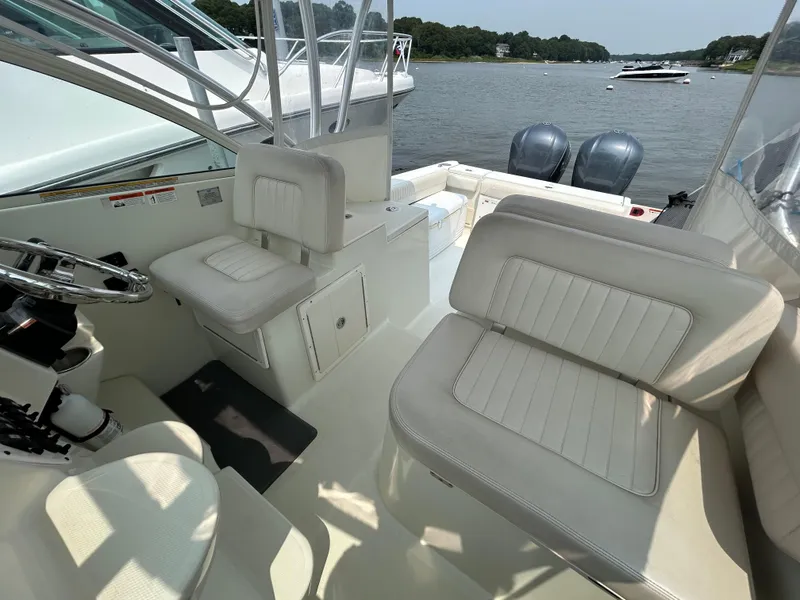 Slide: The Image of 2011 Hydra-Sports 3000 VX boat interior with seating and steering wheel, docked on a calm river. - 30