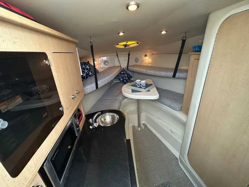 Slide: The Image of Interior of 2011 Hydra-Sports 3000 VX boat with kitchenette, bunk beds, and cozy seating area. - 36