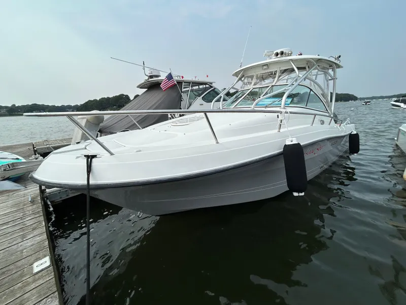 Slide: The Image of 2011 Hydra-Sports 3000 VX boat docked on calm water, featuring sleek design and American flag. - 8