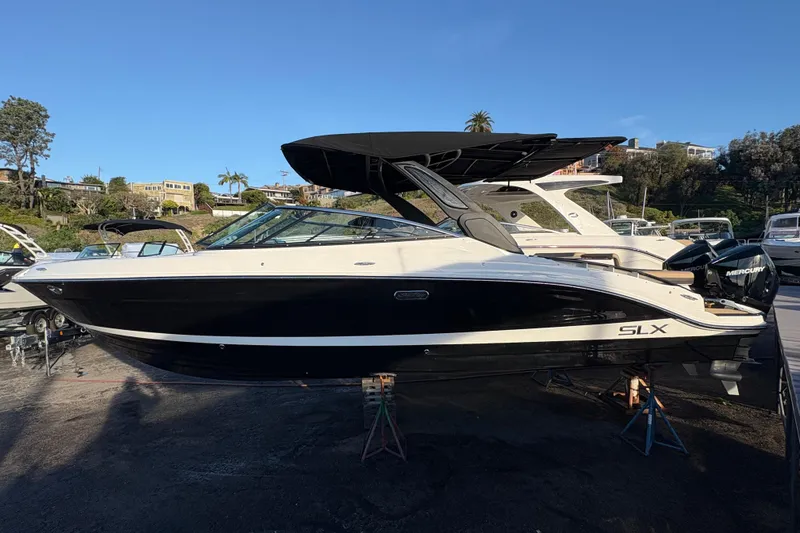 The Image of 2026 Sea Ray SLX 280 Outboard boat displayed outdoors on a sunny day. - 0