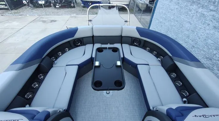 Slide: The Image of 2026 South Bay S224RS pontoon boat interior with gray and blue seating and a central table. - 7
