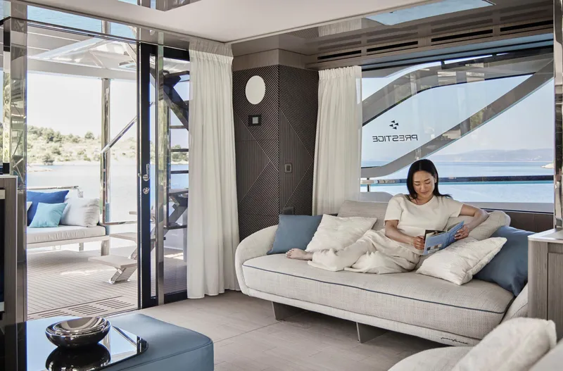 Slide: The Image of Luxurious interior of 2026 Prestige M8 yacht with woman relaxing on sofa. - 29