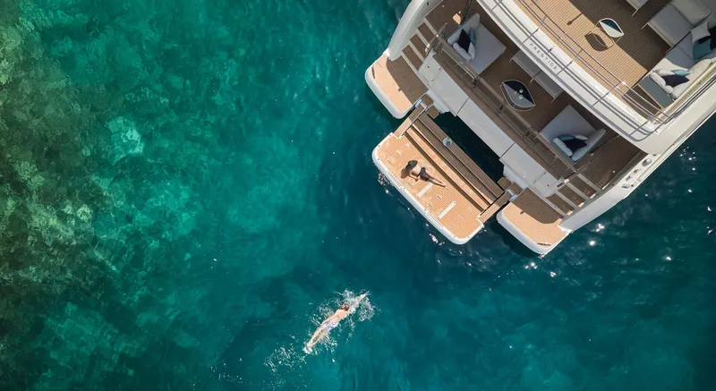 Slide: The Image of Aerial view of Prestige M8 yacht, 2026 model, with swimmer in clear blue water. - 7