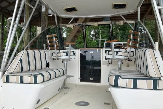 Slide: The Image of 2001 Legacy Boat 28 Express interior with striped seating and helm chairs. - 12