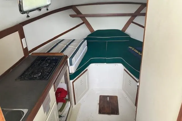 Slide: The Image of Interior of 2001 Legacy Boat 28 Express with compact kitchen and sleeping area. - 14