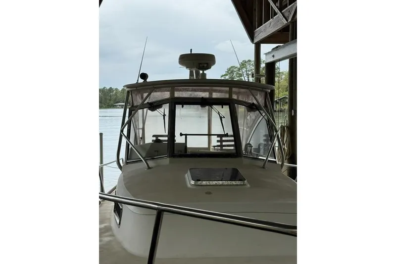 Slide: The Image of 2001 Legacy Boat 28 Express docked under shelter, front view with overcast sky. - 27