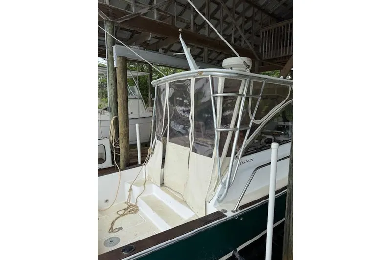 Slide: The Image of 2001 Legacy Boat 28 Express docked, featuring a covered cockpit and sturdy frame. - 29