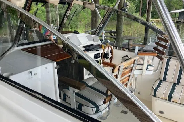 Slide: The Image of 2001 Legacy Boat 28 Express interior with striped seating and wooden accents. - 5