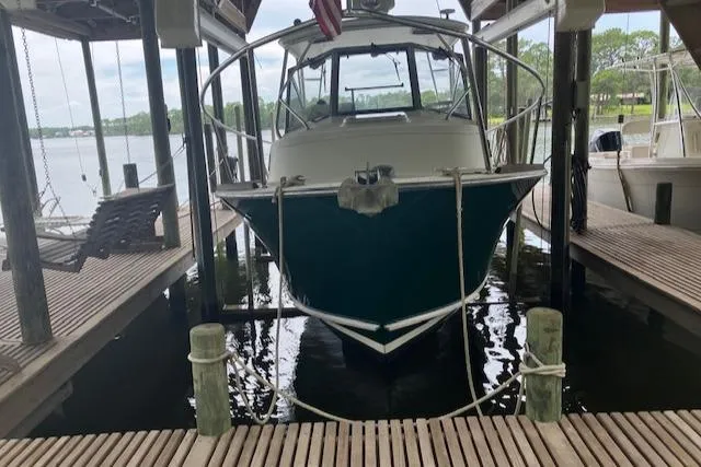 Slide: The Image of 2001 Legacy Boat 28 Express docked in a covered marina. - 8