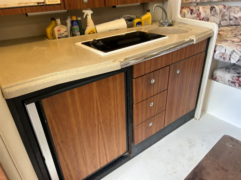 Slide: The Image of 1999 Wellcraft 330 Coastal boat kitchen with wood cabinets, sink, and countertop. - 32