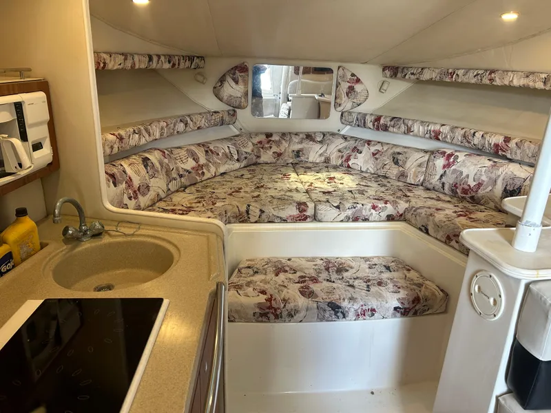 Slide: The Image of 1999 Wellcraft 330 Coastal cabin interior with floral upholstery and compact kitchenette. - 38