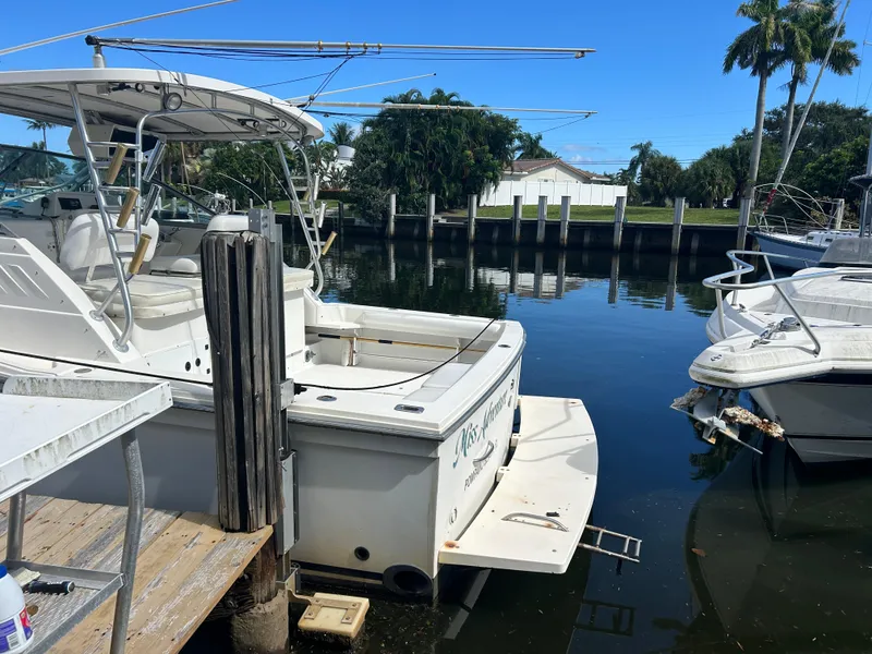 Slide: The Image of 1999 Wellcraft 330 Coastal boat docked in a serene marina setting. - 5
