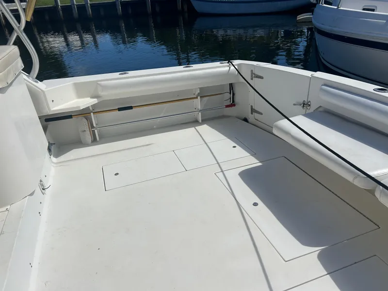 Slide: The Image of 1999 Wellcraft 330 Coastal boat deck, spacious and clean, docked by the water. - 8