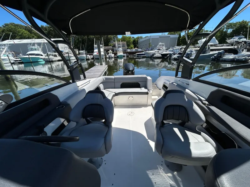 Slide: The Image of 2019 Rinker Q5 OB boat on trailer, red and white, parked outdoors. - 14