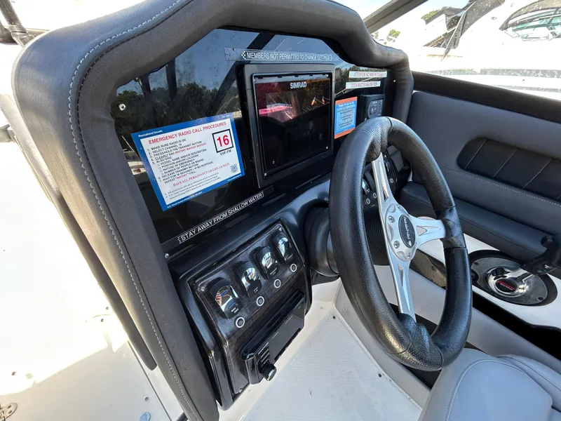 Slide: The Image of 2019 Rinker Q5 OB boat interior with seating, docked at marina. - 18