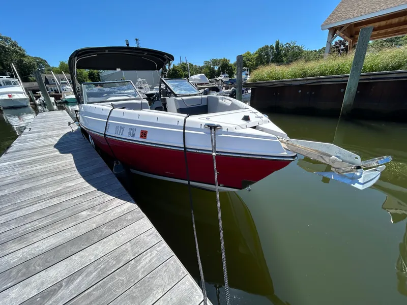 Slide: The Image of 2019 Rinker Q5 OB boat with red and white design on calm water. - 5
