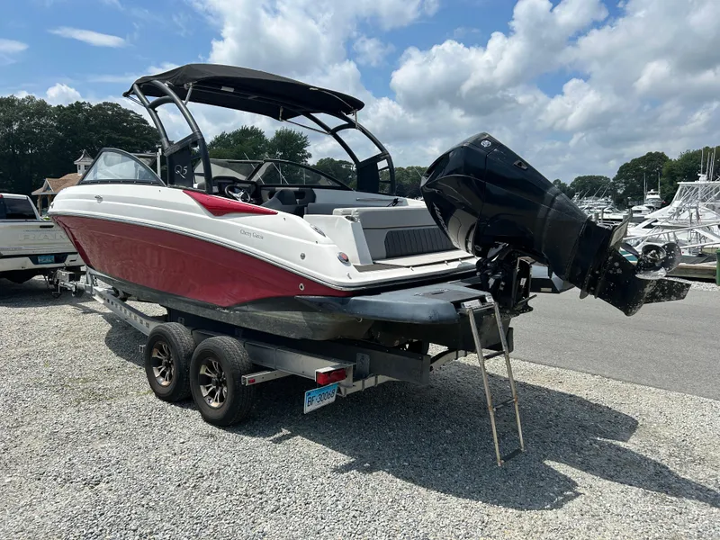 Slide: The Image of 2019 Rinker Q5 OB boat docked at a marina with other vessels. - 8