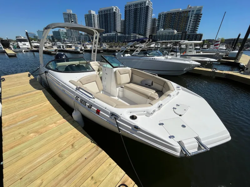 Slide: The Image of 2022 NauticStar 243 DC boat docked at marina with city skyline. - 1