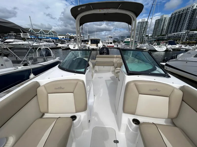 Slide: The Image of 2022 NauticStar 243 DC boat docked at marina, featuring spacious seating and modern design. - 18