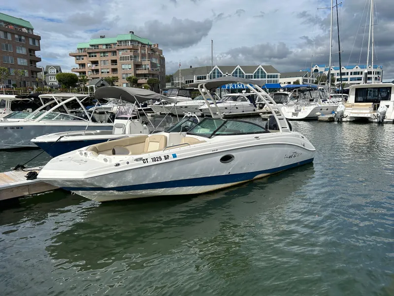Slide: The Image of 2022 NauticStar 243 DC boat docked in a marina with other vessels. - 2