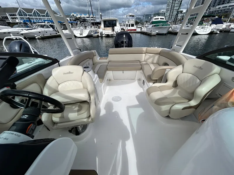 Slide: The Image of 2022 NauticStar 243 DC boat interior with plush seating at marina. - 21