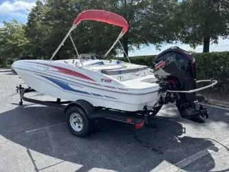 Slide: The Image of 2023 Tahoe T18 boat with trailer, parked outdoors under trees. - 5