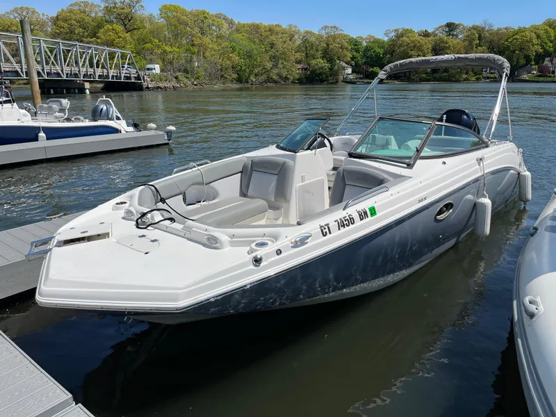 The Image of 2022 NauticStar 243 DC boat docked on a calm river. - 0
