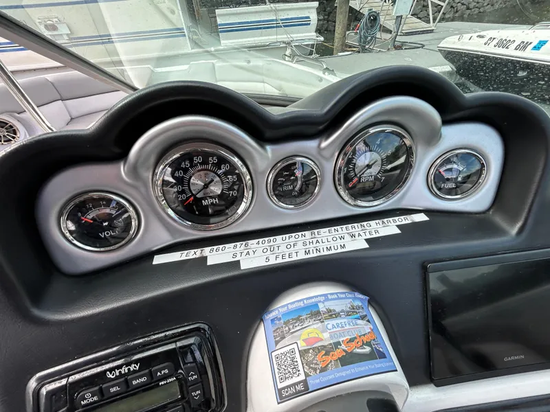 Slide: The Image of Dashboard of 2022 NauticStar 243 DC boat with gauges and warning label. - 11