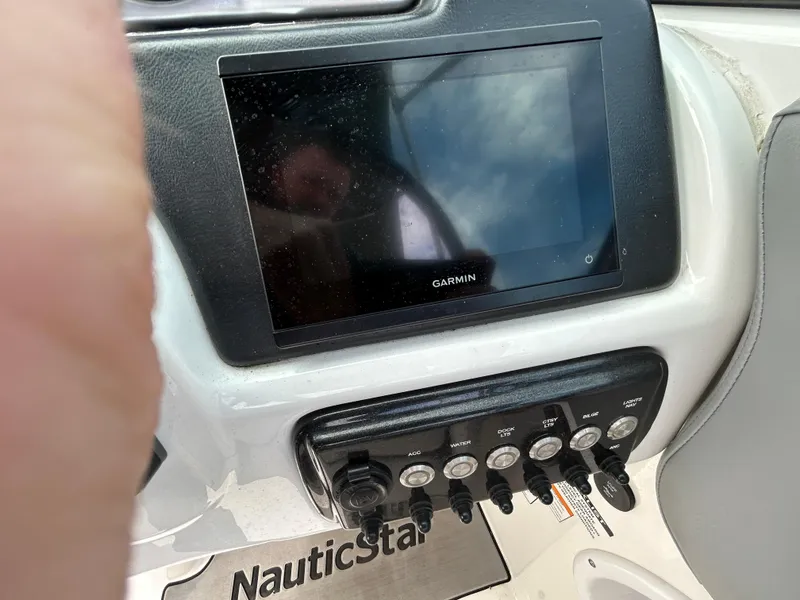 Slide: The Image of Garmin display and controls on 2022 NauticStar 243 DC boat dashboard. - 12