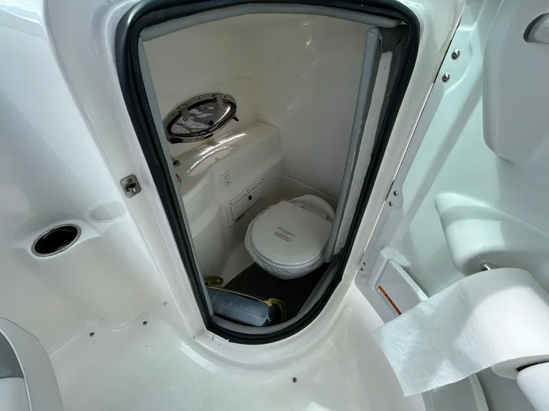 Slide: The Image of 2022 NauticStar 243 DC boat interior bathroom with toilet and window. - 14