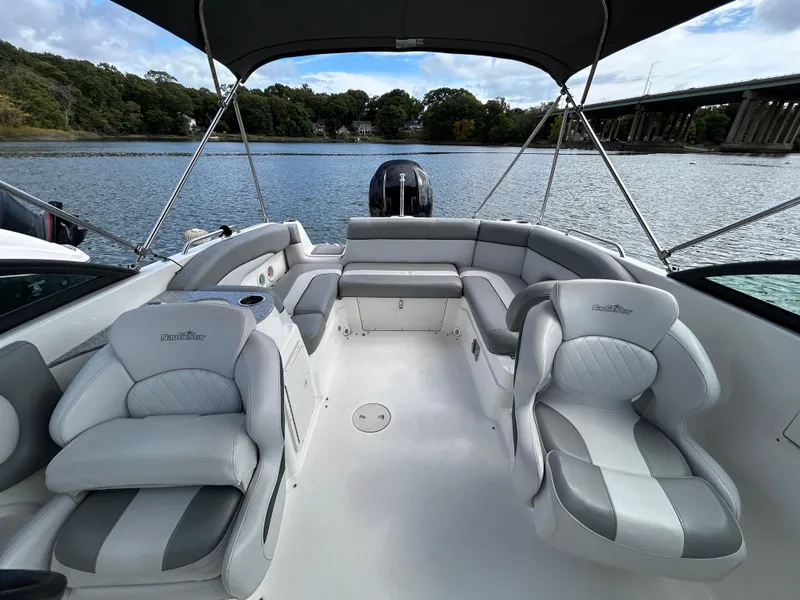 Slide: The Image of 2022 NauticStar 243 DC boat interior with plush seating on a serene lake. - 19