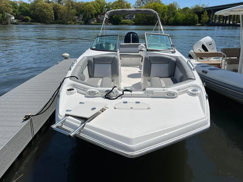 Slide: The Image of 2022 NauticStar 243 DC boat docked on a serene lake. - 2