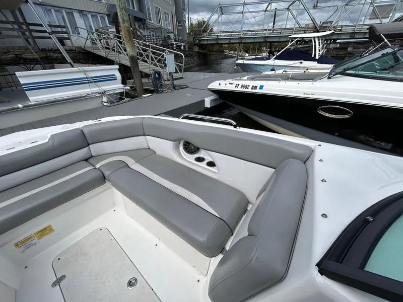 Slide: The Image of 2022 NauticStar 243 DC boat with gray seating, docked near other boats. - 20