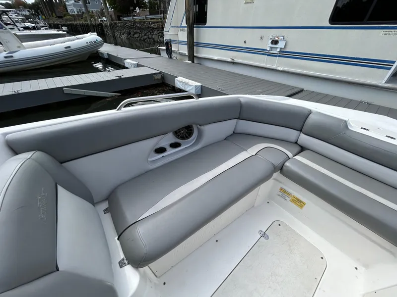 Slide: The Image of 2022 NauticStar 243 DC boat interior with gray seating at a marina. - 21