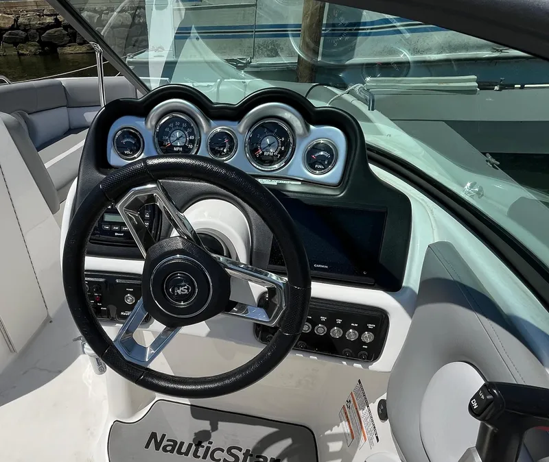 Slide: The Image of 2022 NauticStar 243 DC boat dashboard with steering wheel and gauges. - 6
