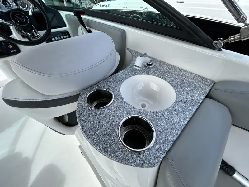 Slide: The Image of 2022 NauticStar 243 DC boat interior with sink and cup holders. - 9