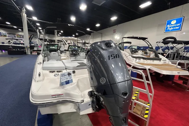 Slide: The Image of 2026 Chaparral 21 SSi Ski & Fish OB boat displayed indoors with 150 HP engine. - 6