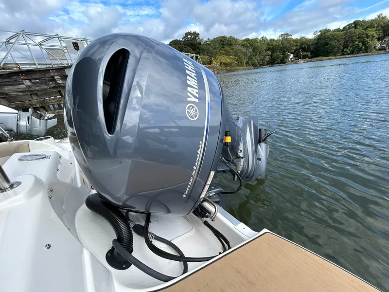 Slide: The Image of 2021 NauticStar 203DC Sport Deck with Yamaha outboard motor on a serene lake. - 10