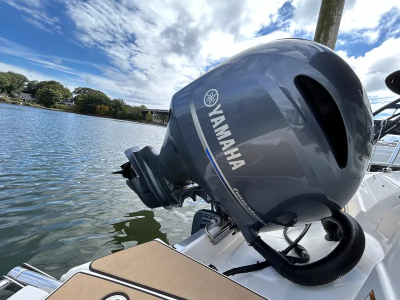 Slide: The Image of Yamaha outboard motor on 2021 NauticStar 203DC Sport Deck boat by the water. - 11