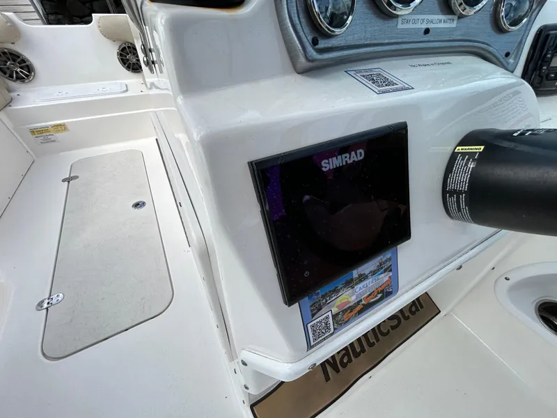 Slide: The Image of 2021 NauticStar 203DC Sport Deck boat dashboard with Simrad display and controls. - 12