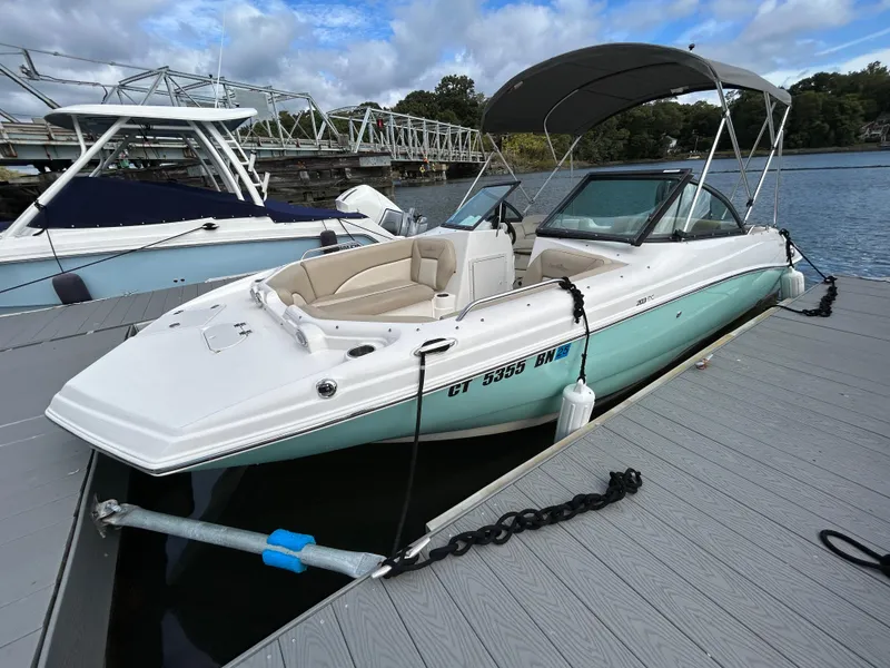 Slide: The Image of 2021 NauticStar 203DC Sport Deck boat docked on a sunny day. - 2