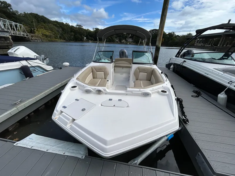 Slide: The Image of 2021 NauticStar 203DC Sport Deck boat docked on a calm lake. - 3