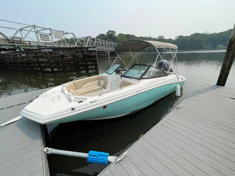 Slide: The Image of 2021 NauticStar 203DC Sport Deck boat docked on calm water. - 4