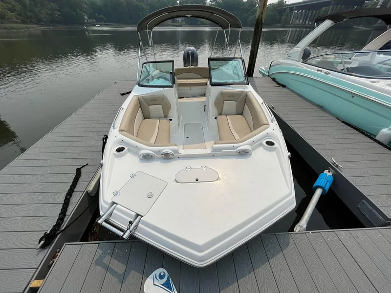 Slide: The Image of 2021 NauticStar 203DC Sport Deck boat docked on calm water. - 5
