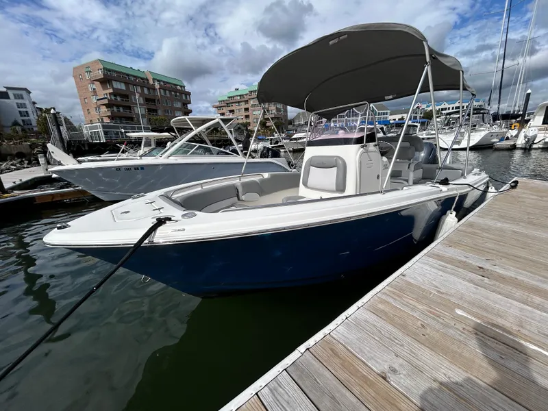 The Image of 2021 NauticStar 2102 Legacy boat docked at marina under cloudy sky. - 0