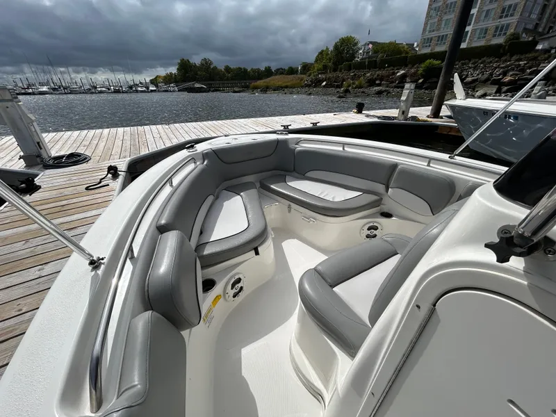 Slide: The Image of 2021 NauticStar 2102 Legacy boat interior with gray seating at dock. - 17
