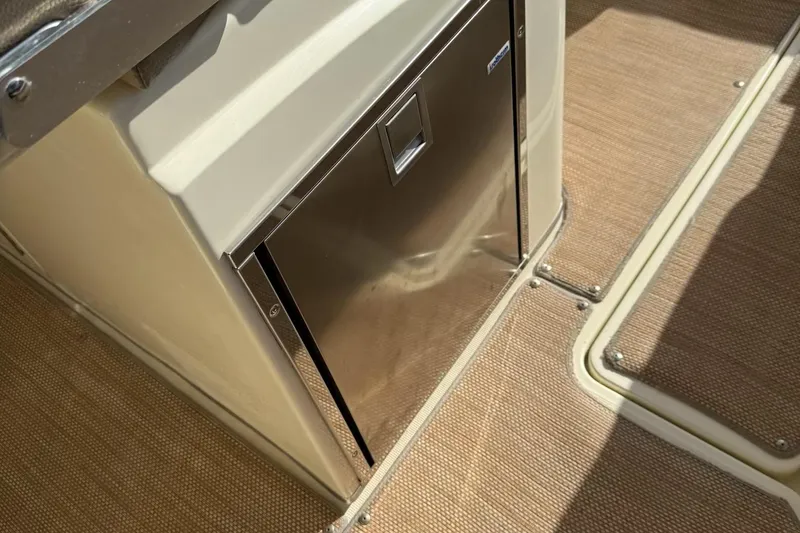 Slide: The Image of 2019 Chris-Craft Catalina 30 interior with stainless steel refrigerator and beige flooring. - 14